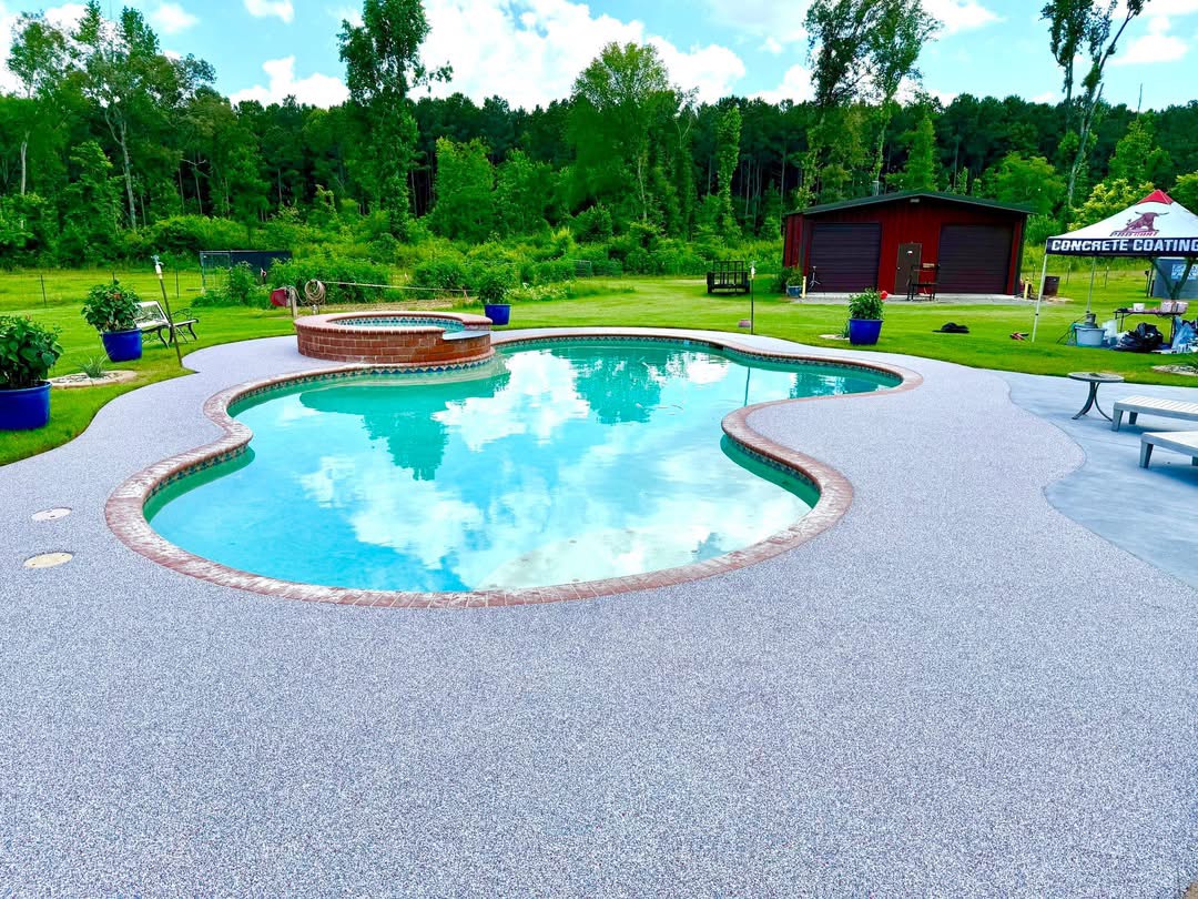 Pool deck finished in blue-gray speckled rubber surfacing with brick coping