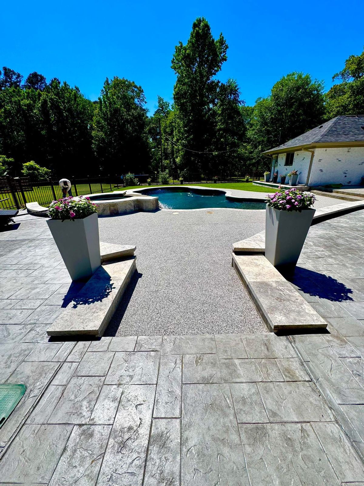 Finished pool deck with a light stone coping band creating a clean, finished transition