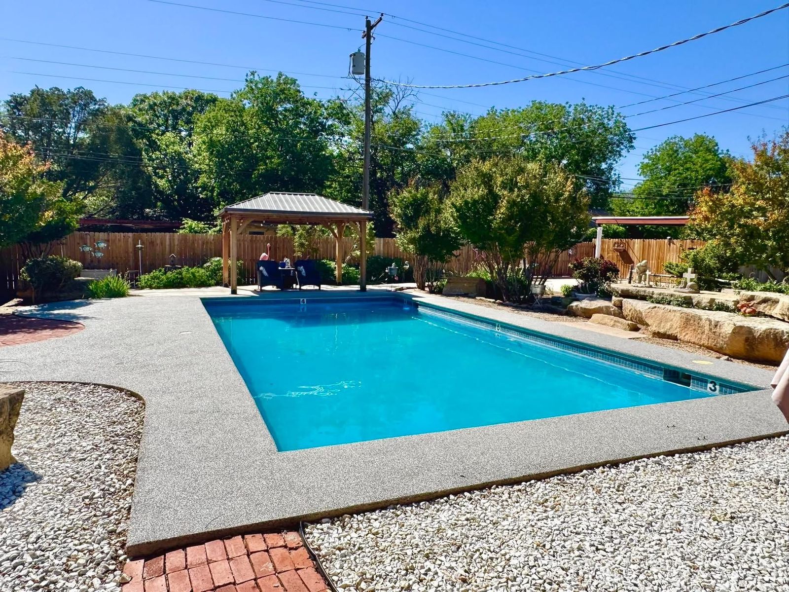 Finished backyard pool deck with a gazebo and rubber surfacing